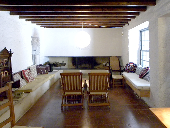 The ground floor living room with the fireplace and windows and doors to the courtyard